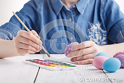 Beautiful young woman painting easter eggs. Cozy home atmosphere. Easter Stock Photo