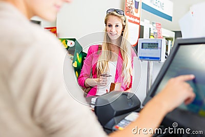 Beautiful young woman paying for her groceries Stock Photo