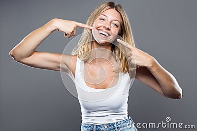 Beautiful young woman with perfect smile over gray background. Stock Photo