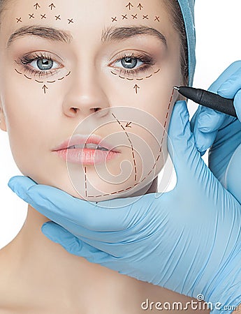 Beautiful young woman with perforation lines on her face before plastic surgery operation. Stock Photo