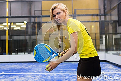 Beautiful young woman playing paddle tennis indoor. Stock Photo