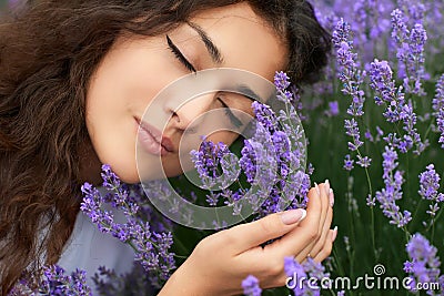 Beautiful young woman portrait on lavender flowers background, face closeup Stock Photo