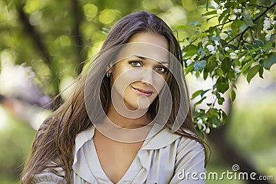 Beautiful young woman portrait next to a branch of a blossoming Stock Photo