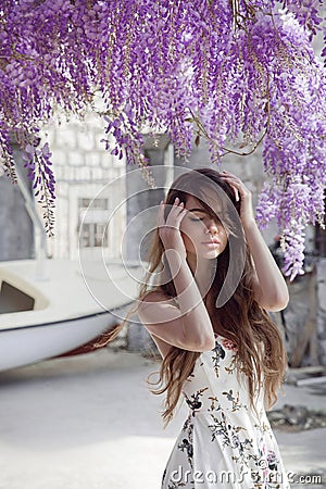 Beautiful young woman portrait over wisteria blossom. Attractive Stock Photo