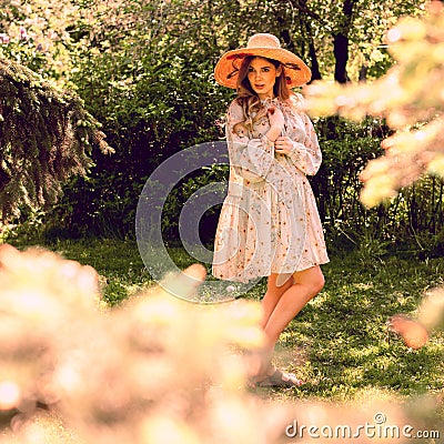 Beautiful young woman posing in the Park. Summer dress and hat Stock Photo