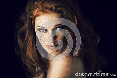 Beautiful young woman with red hair and freckles portrait, beauty shoot on dark background Stock Photo