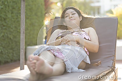 Beautiful young woman relaxing on beach chair Stock Photo