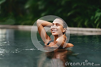 Beautiful young woman relaxing in spa swimming pool. Stock Photo