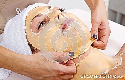 Beautiful young woman remove facial mask in a beauty center Stock Photo