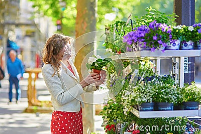 Beautiful young woman selecting flowers at market Stock Photo