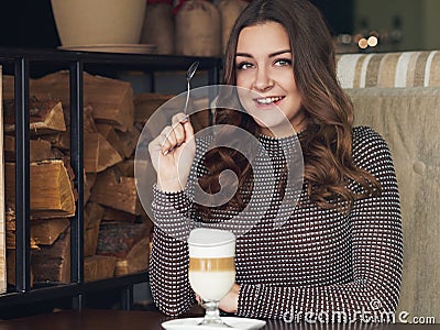 Beautiful young woman sitting in italian style cafe with cup of Stock Photo