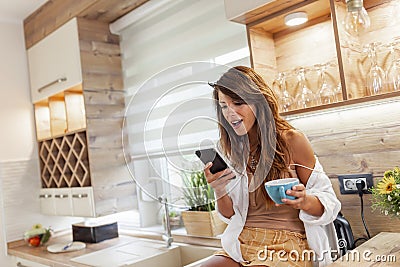 Woman surfing the Internet using smart phone and drinking coffee Stock Photo