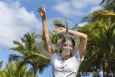 Beautiful young woman smiling raising her arms feeling happy Stock Photo