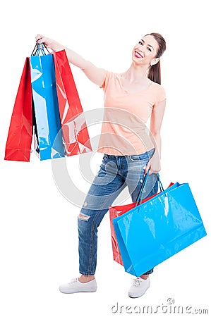 Beautiful young woman standing and holding shopping bags feeling Stock Photo