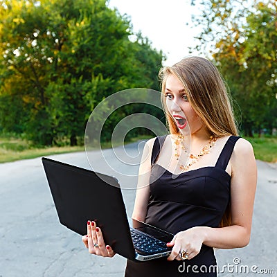 Beautiful young woman stares at a laptop while Stock Photo