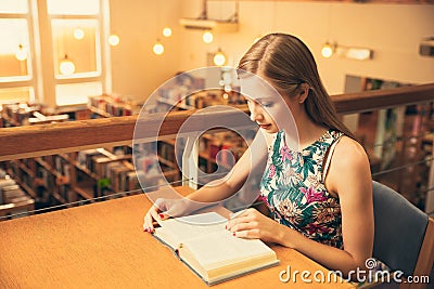 Beautiful young woman student in library Stock Photo