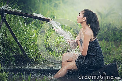 Beautiful young woman takes bath naturally flows Stock Photo