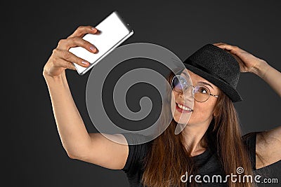 Beautiful young woman taking selfie on smartphone. Stock Photo