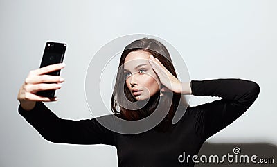 Beautiful young woman taking selfie on smartphone Stock Photo