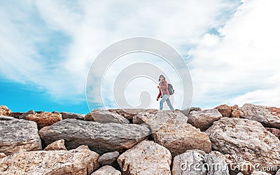 Beautiful young woman traveler walking on rocks rocks against th Stock Photo