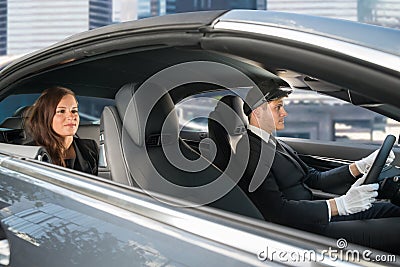 Young Woman Riding In A Car With Chauffeur Stock Photo