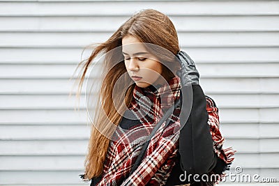 Beautiful young woman with a trendy vintage scarf near a wooden Stock Photo