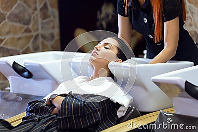 Beautiful young woman washes hair in a beauty salon. Stock Photo