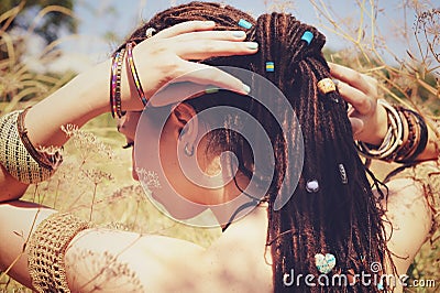 Beautiful young woman wearing dreadlocks hairstyle gathered in a ponytail and decorated assorted beads Stock Photo