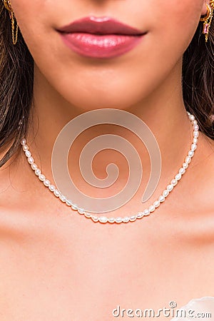 Beautiful young woman wearing a pearl necklace and golden earings. Beautiful valentine`s gift Stock Photo