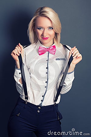 Beautiful young woman wearing tophat, bow-tie and braces against Stock Photo