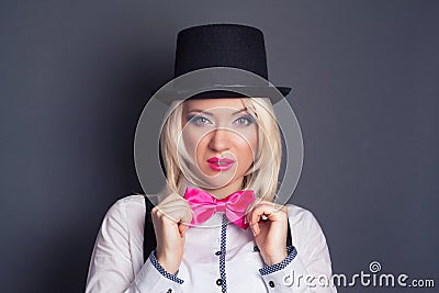 Beautiful young woman wearing tophat, bow-tie and braces against Stock Photo