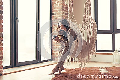 Woman wearing cashmere nightwear relaxing in cabin near fireplace Stock Photo