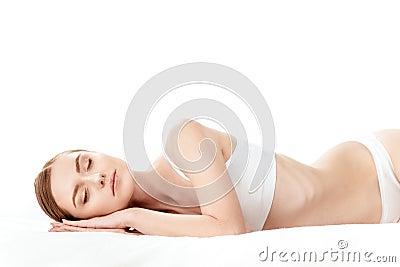 Beautiful young woman in white underwear sleeping isolated on white Stock Photo