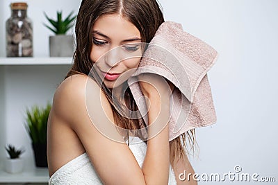 Beautiful young woman wipes her hairs with a towel. Stock Photo