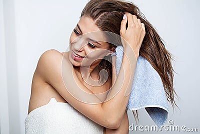 Beautiful young woman wipes her hairs with a towel. Stock Photo