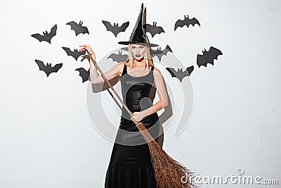 Beautiful young woman in witch costume with hat and broom Stock Photo