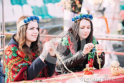 Beautiful young women busy creating souvenirs from straw at Cele Editorial Stock Photo
