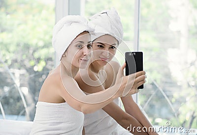 Beautiful young woman relaxing using smartphone selfie in spa Stock Photo