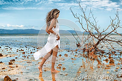 Beautiful ypung stylish woman in white dress on the beach Stock Photo