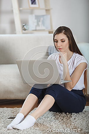 Beautiful ypung woman using laptop at home Stock Photo