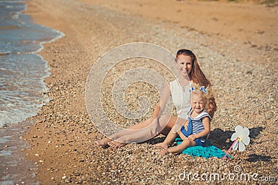 Beautifull mother lady with cute daughter girl on a beach sea side stylush dressed Stock Photo