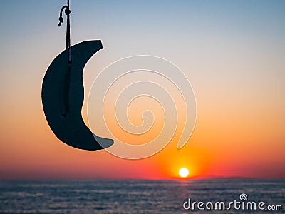 Beautifull sunrise in Greece with a model moon and the sun rising from the sea in the background. Focus on the moon Stock Photo