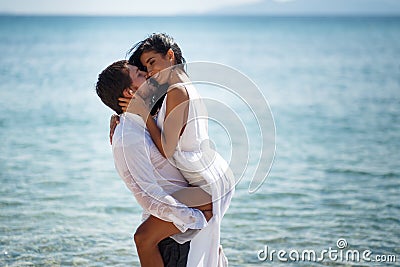 Beautiful wedding couple kissing and embracing in turquoise water, mediterranean sea in Greece. Stock Photo