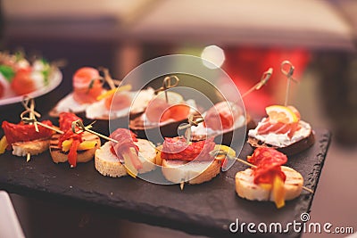 Beautifully decorated catering banquet table with different food snacks and appetizers with sandwich, caviar, fresh fruits Stock Photo