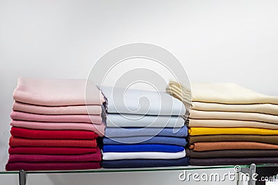 beautifully folded knitted multi-colored woolen things in piles. wardrobe Stock Photo