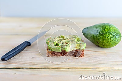 Beautifully rye toast bread with cut green avocado. Stock Photo