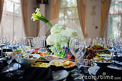 Beautifully set banquet table. Snacks, flowers and wine glasses. Stock Photo