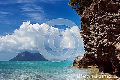 Beautuful tranquil sea scene with cloudy sky and a green cliff Stock Photo