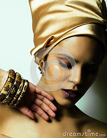 Beauty african woman in shawl on head, very elegant look with gold jewelry close up mulatto makeup Stock Photo