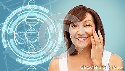 Senior woman touching her face over dna molecule Stock Photo